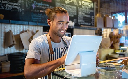 Kellner tippt etwas in ein Kassensystem ein