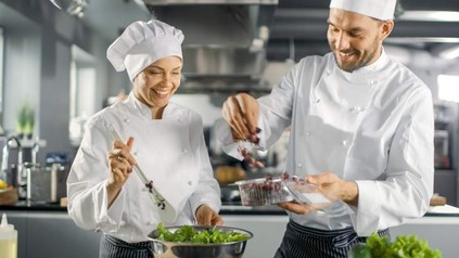 Zwei fröhliche Köche bei der Arbeit