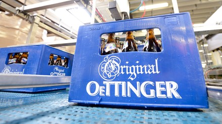 Eine Kiste Oettinger-Bier steht am 31.07.2014 in der Oettinger Brauerei in Braunschweig (Niedersachsen) auf einem Transportband.