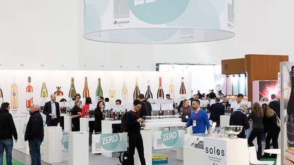 Besucher an der ProWein Zero Tasting Bar in Halle 5 auf der ProWein Düsseldorf, mit Zero-Beschilderung, Verkostungsstationen und alkoholfreien Produkten.