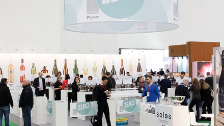 Besucher an der ProWein Zero Tasting Bar in Halle 5 auf der ProWein Düsseldorf, mit Zero-Beschilderung, Verkostungsstationen und alkoholfreien Produkten.