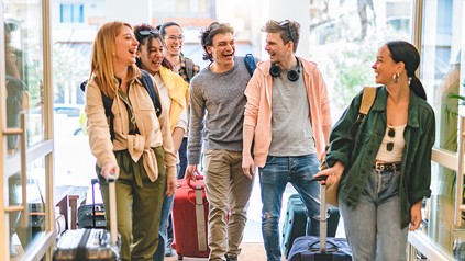 Gruppe von Urlaubern mit Koffern in einem Gebäude auf dem Weg zur Reise