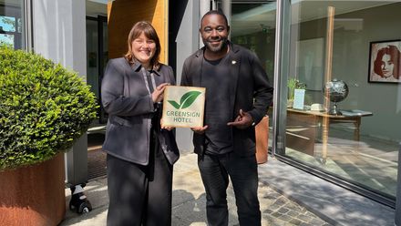 Anna Sass Santo übergibt Nelson Müller das GreenSign-Label.