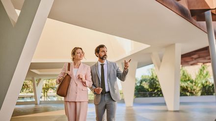 Geschäftsmann und Geschäftsfrau in Businesskleidung gehen durch die moderne Lobby eines Hotels