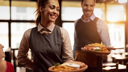 Zwei Kellner bringen Speisen