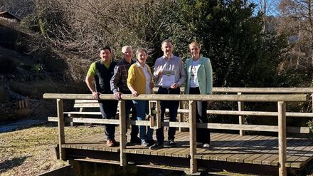 Familie König erhält die Urkunde „Wanderbares Deutschland“ von Vertretern der Region auf einer Holzbrücke in Münsingen-Gundelfingen.