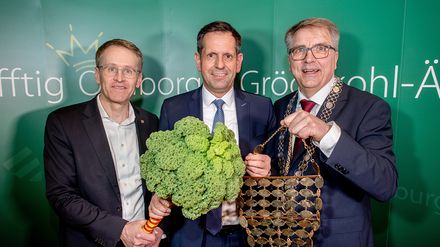 Daniel Günther, Olaf Lies und Oldenburgs Oberbürgermeister Jürgen Krogmann mit einer Grünkohlpflanze beim Oldenburger Grünkohlessen
