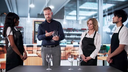 Diverses Team aus Servicekräften in einem Restaurant erhält Schulung zu Service-Standards