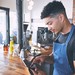 Ein Restaurantmitarbeiter bedient in einem Café ein Tablet an der Theke