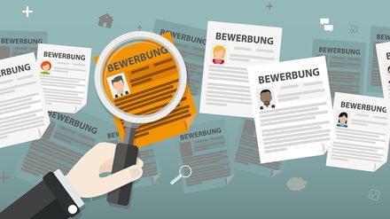Hand hält Lupe über mehrere Bewerbungsunterlagen mit Lebensläufen