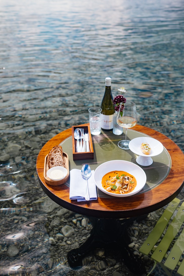 Gedeckter Tisch am Bodensee mit Bouillabaisse, Wein und Brot