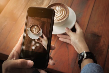Haben Influencer ihren Glaubwürdigkeitszenit überschritten? (Foto: © Jirapong)
Frau fotografiert Cappuccino mit Smartphone