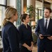 Neu beförderter Teamleiter bespricht sich vor dem Service mit Mitarbeitern in einem modernen Hotelrestaurant.