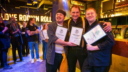 Die drei Platzierten von Bar Wars 2.0 stehen im Classic Rock Café Stuttgart mit ihren Urkunden