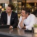 Vier Mitarbeiter verschiedener Altersgruppen besprechen sich an einem Tresen in einem Restaurant. Vor ihnen steht ein Tablet.