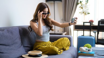 Junge Frau im Hotelzimmer mit Handy