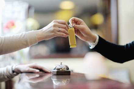 Frau übergibt anderer Frau Zimmerschlüssel