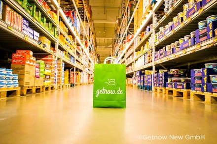 Eine grüne Papiertüte auf der getnow.de steht in einem Supermarkt