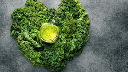Ein grüner Smoothie inmitten frischen Grünkohls