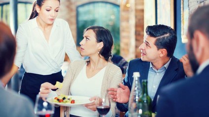Eine Gruppe in einem Restaurant beschwert sich bei einer Kellnerin über das Essen