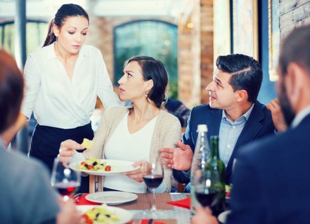 Eine Gruppe in einem Restaurant beschwert sich bei einer Kellnerin über das Essen