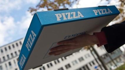 Ein Lieferant mit einem Pizzakarton
