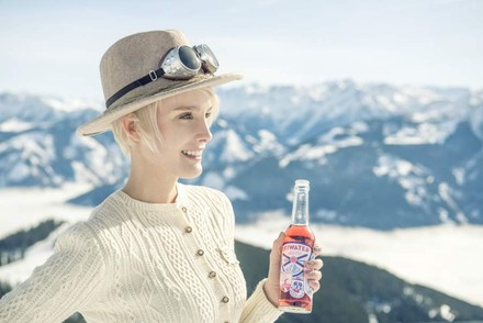 Lachende Frau mit Getränk in der Hand