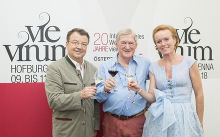 Mag. Willi Klinger, Hugh Johnson und Mag. Alexandra Graski-Hoffmann stoßen gemeinsam vor dem Banner der VieVinum an