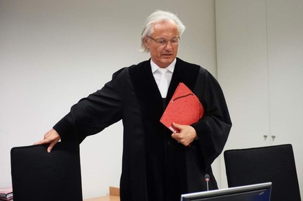 Richter Manfred Winterscheidt in Richterrobe setzt sich auf einen Stuhl im Oberlandesgericht