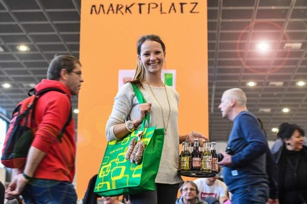 Frau mit grüner Tasche auf Messe