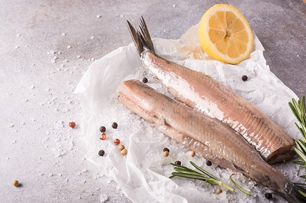 Hering auf Eis mit Pfefferkörnern und Zitrone