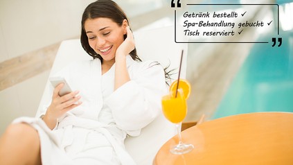 Junge Frau relaxt im Hotel-Spa und benutzt ein Handy.