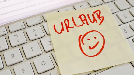 Übrige Tage Urlaub aus dem Vorjahr müssen normalerweise bis zum 31. März des Folgejahres in Anspruch genommen werden, sonst verfallen sie. (Foto: © Gina Sanders/stock.adobe.com)
Notiz auf Tastatur „Urlaub“