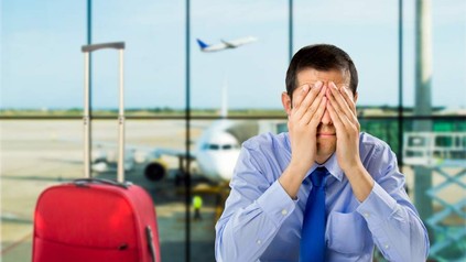 Ein Mann verbirgt sein Gesicht am Flughafen in den Händen