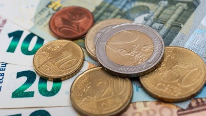 Geldscheine und Euromünzen liegen auf einem Tisch