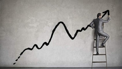 Mann auf Leiter zeichnet Trendchart auf Wand