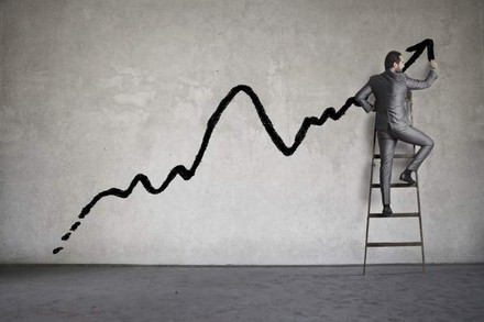 Mann auf Leiter zeichnet Trendchart auf Wand