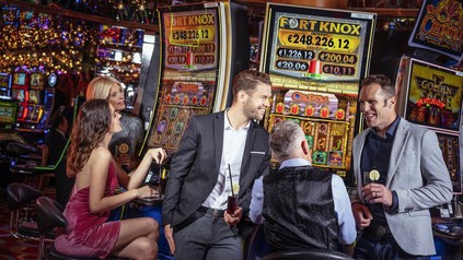 Casinobesucher vor Spielautomaten