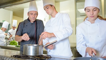 Junge Köche bei der Arbeit mit ihrem Ausbilder
