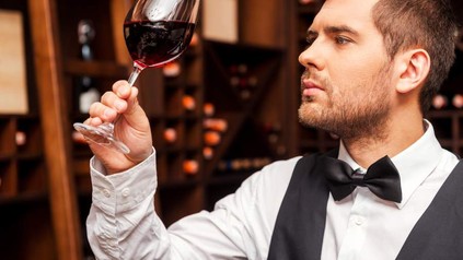 Mann betrachtet Wein im Glas