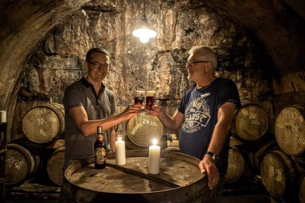 Zwei Männer stoßen in der Schatzkapelle der Miltenberger Brauerei Faust fröhlich an