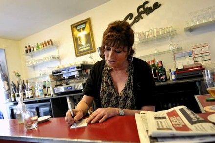 Frau an Theke schreibt auf einen Zettel