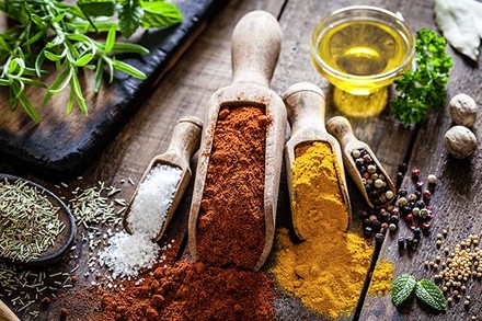 Diverse Gewürze und Kräuter auf einem Holztisch angerichtet