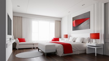 Hotelzimmer in weiß gehalten und mit orangenen Highlights