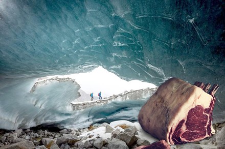In einer Gletscherhöhle an der zwei Bergsteiger vorbeilaufen liegt ein großes Stück Fleisch