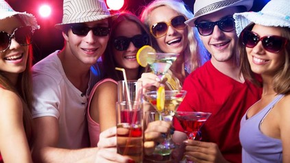 Eine gruppe Jugendlicher stößt mit diversen Drinks an