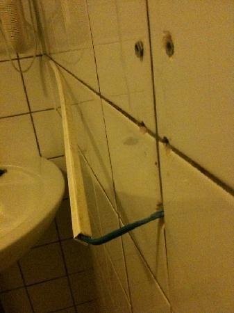 Kabel ragen aus einer Badezimmerwand heraus