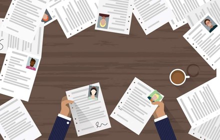 Zwei Hände mit Bewerbungen in der Hand