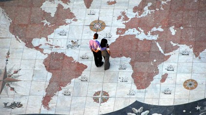 Paar steht auf Landkarte und betrachtet Afrika