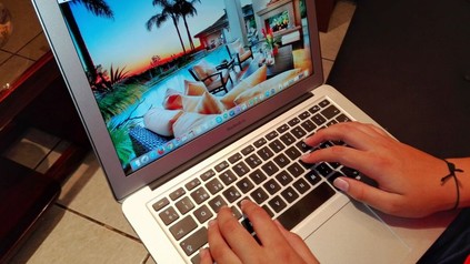 Frau tippt etwas in Laptop